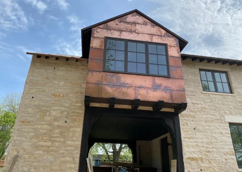 Copper metal panel facade on a stone building for Skylight Installation in Dillon